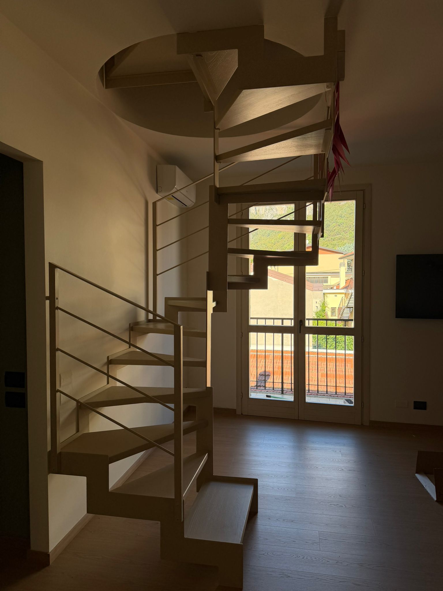 La nuova scala su misura si distingue per un effetto visivo leggero e monocromatico, una struttura in ferro con profilo a “ginocchio” sagomato nella parte superiore e inferiore, pedate in legno di frassino spazzolato che donano calore all’ambiente e una r